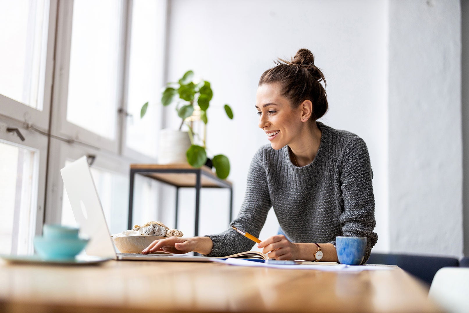 A smiling woman using laptop with career in finance.