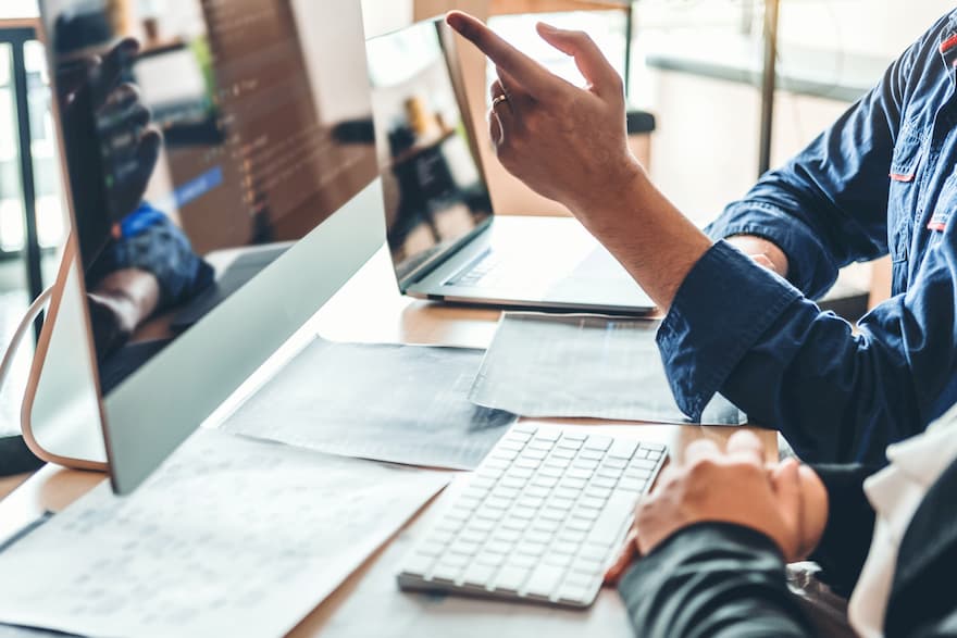 Analyst working while pointing to a screen.