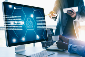 Cyber security professionals viewing a digital padlock and encrypted data on a computer screen.