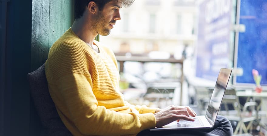 A data scientist working on a laptop in a  start-up office.