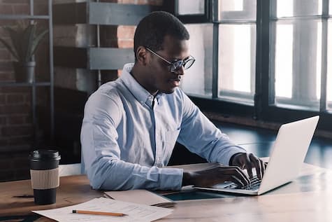 The UNSW graduate diploma in applied finance online student is looking at his laptop