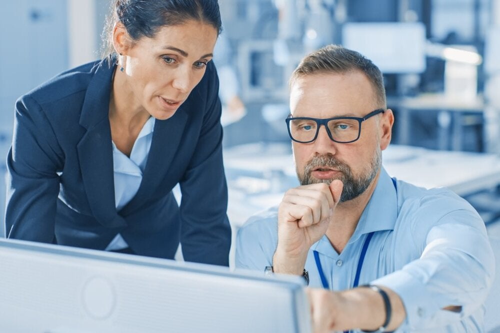 An analyst talking with a coworker