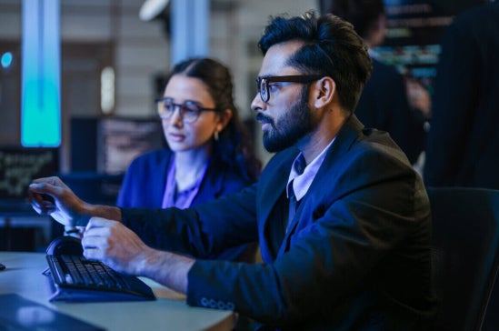 Cyber security professionals reviewing threat data on screens.