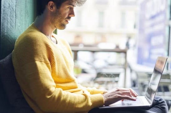 A data scientist working on a laptop in a start-up office