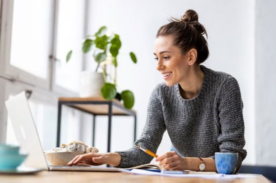 A smiling woman with career in finance using laptop