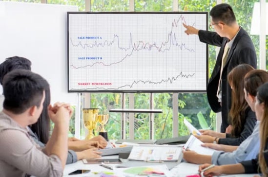 A data scientist presenting some information to colleagues on a computer screen