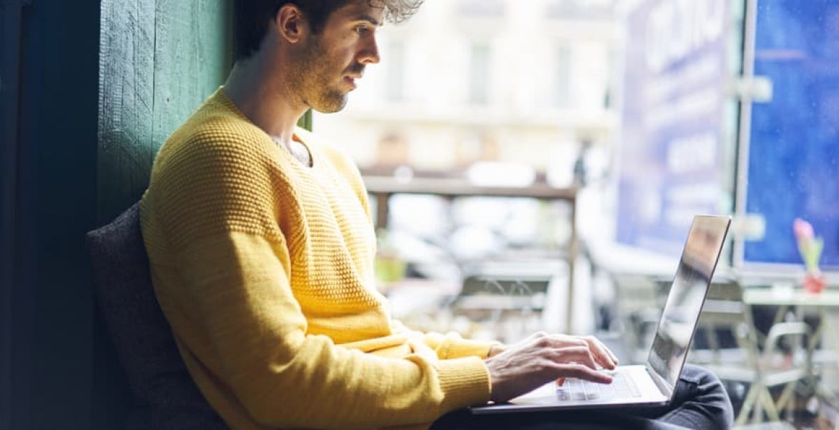 A data scientist working on a laptop in a start-up office.
