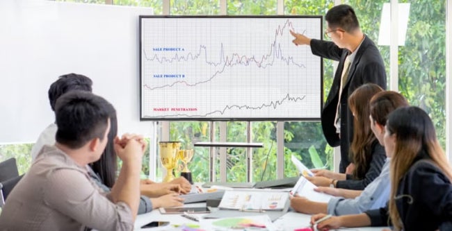 A data scientist presenting some information to colleagues on a computer screen