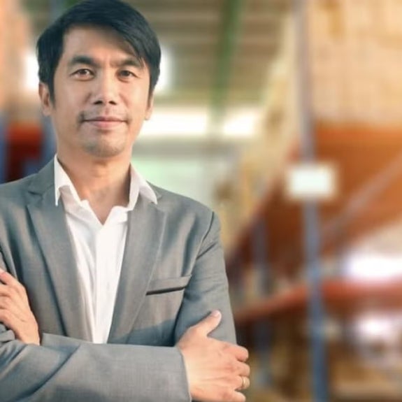 A social entrepreneur standing and smiling with his arms crossed