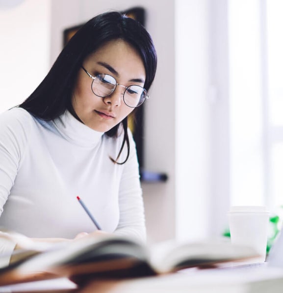 Mid-career professional in Singapore studying for a Master of Analytics on a laptop.