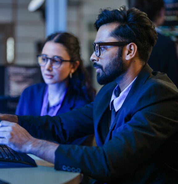 Cyber security professionals reviewing threat data on screens.