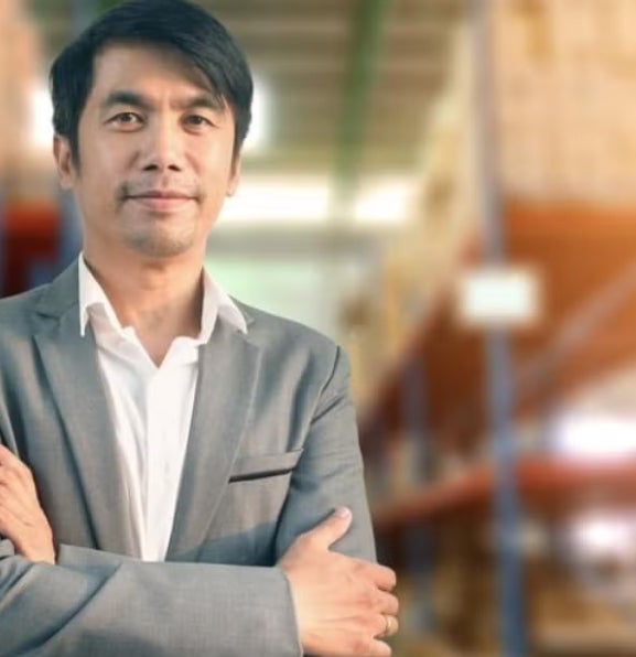 A social entrepreneur standing and smiling with his arms crossed