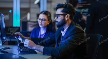 Cyber security professionals reviewing threat data on screens.