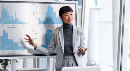 A businesswoman presents a finance chart during a meeting in an office setting.