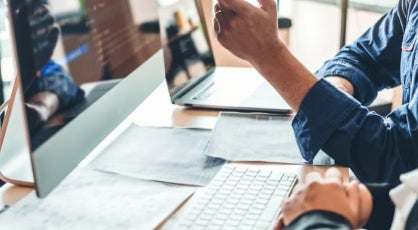 A cybersecurity expert points at code on a monitor