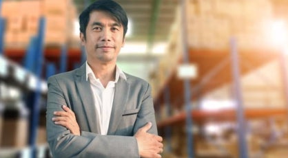 A social entrepreneur standing and smiling with his arms crossed