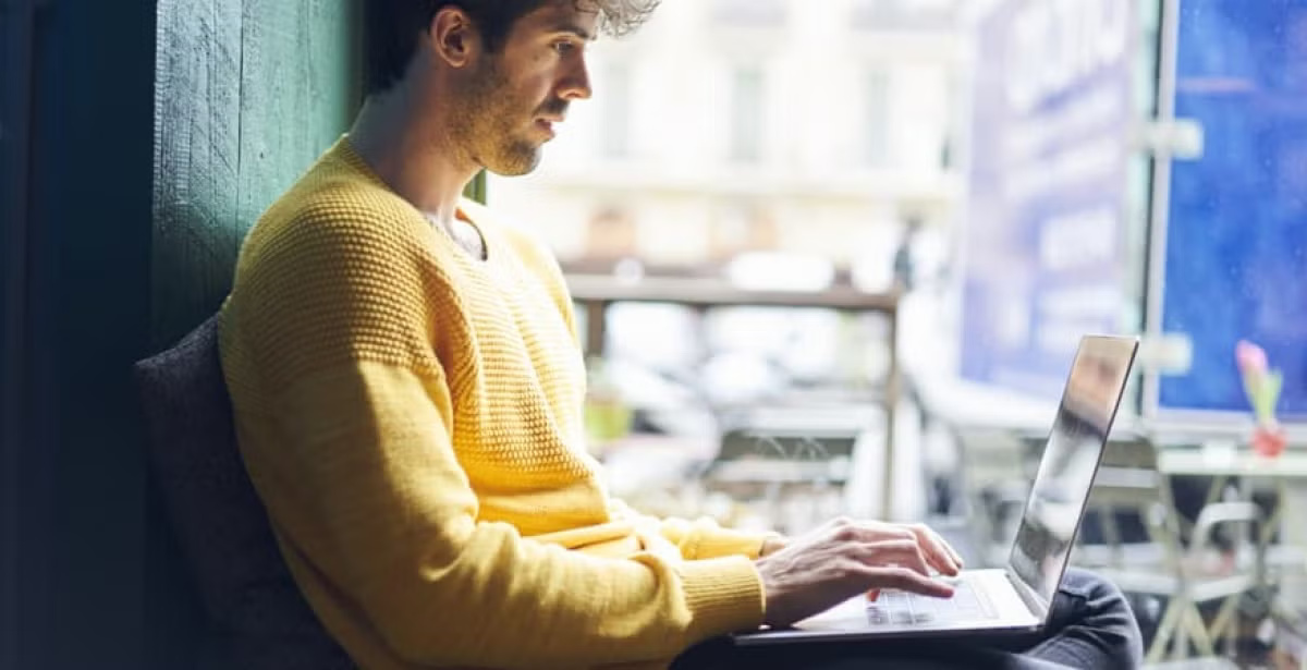 A data scientist working on a laptop in a start-up office