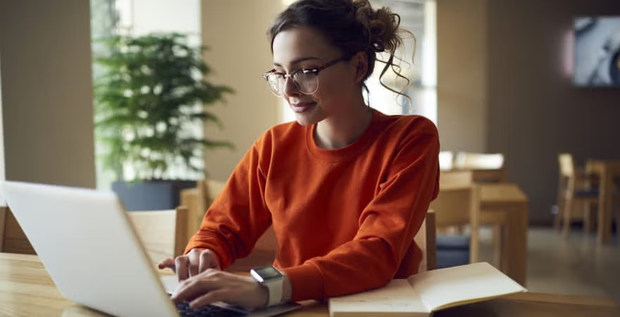 A journalist writing an article on her laptop