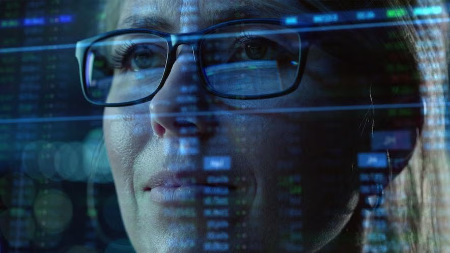 A cyber security professional looks thoughtfully at a computer screen