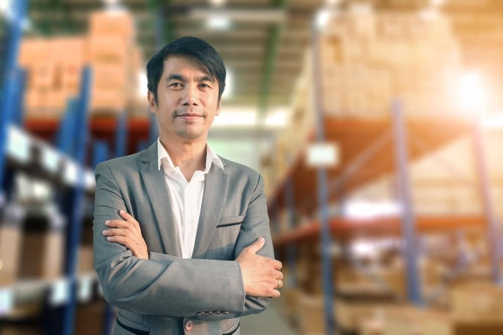 A social entrepreneur standing and smiling with his arms crossed