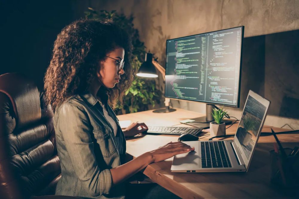 A female cyber security expert working on her laptop